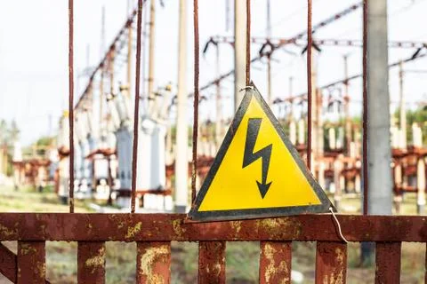 Close-up old aged rusty triangle metal plate with High voltage warning sign.  Фото
