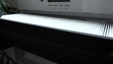 A close-up of an old air filter being replaced with a new one. Stock Footage 320047558
