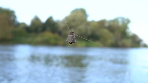 Close-up of an old brass bell hanging from a fishing line. The bell rings to Stock Footage 163540908