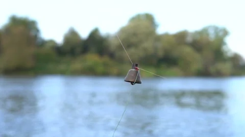 Close-up of an old brass bell hanging from a fishing line. The bell falls from Stock Footage 163596422