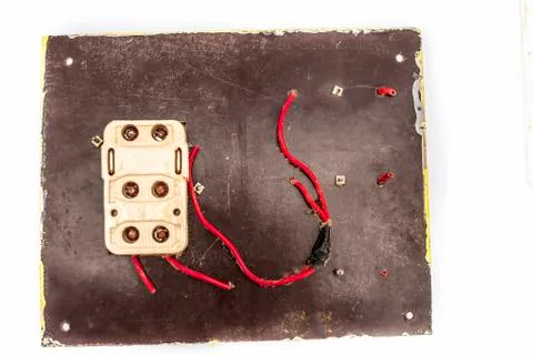 Close up of old broken switch board with wires coming out of it isolated on w Stock Photos