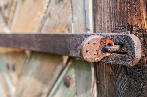Close-up of an old, corroded and rusty padlock closing the wooden door. Stock Photos