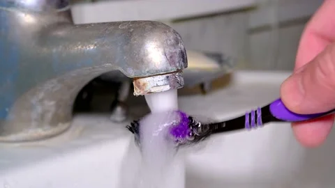 Close-up of old corroded faucet from which water flows. Washing toothbrush. Stock Footage 218097483