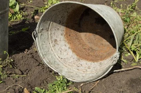 Close - up of an old dirty rusty iron bucket lying on the ground Stock Photos