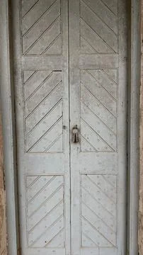 Close-up of an old double door featuring a light gray painted finish, diagona 스톡 사진