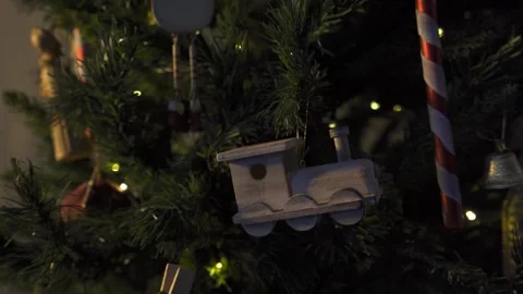 Close up on old fashioned train ornament on Christmas tree with lights blinking Stock Footage 257656046