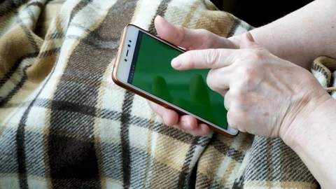 Close-up of an old female hands with a mobile phone Stock Footage 128657338