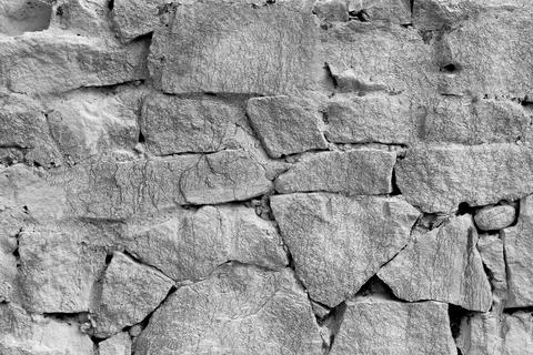 Close-up of old gritty stone structure in greyscale Stock Photos