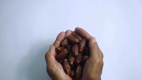 Close up old hands holding dates fruit on isolated white background Stock Footage 287681880