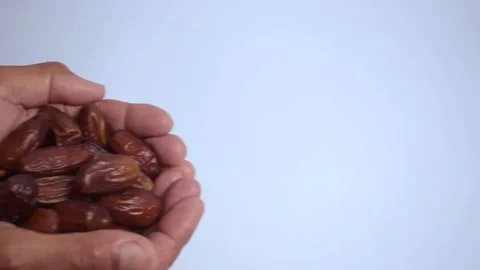 Close up old hands holding dates fruit on isolated white background Stock Footage 287681902