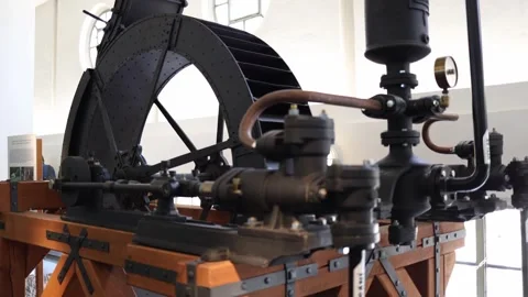 A close-up of an old industrial steam engine in a bright museum hall. Black iron Stock Footage 304884710
