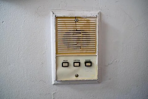 Close up of old intercom system with worn buttons on wall Stock Photos
