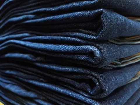 Close-up old Jeans trousers stack background texture. Stock Photos
