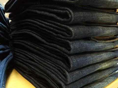 Close-up old Jeans trousers stack background texture. Fotos de archivo