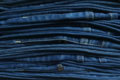 Close-up old Jeans trousers stack background texture. Stock Photos
