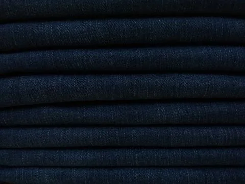 Close-up old Jeans trousers stack background texture. Stock Photos