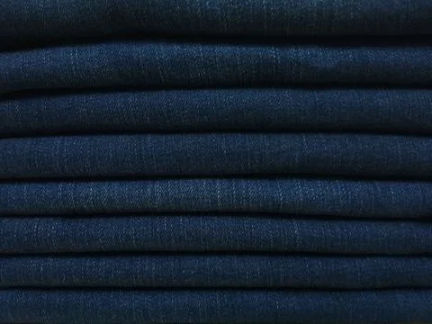 Close-up old Jeans trousers stack background texture. Stock Photos