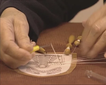 Close up old lady's hands, making bobbin lace, using a pattern Stock Footage 52996491
