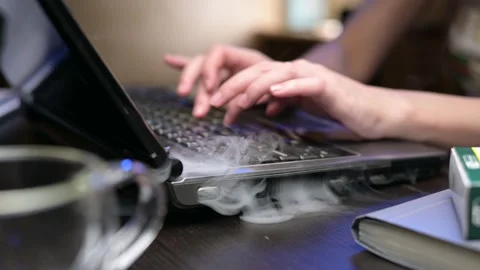 A close-up of an old laptop falling apart with smoke coming out of it Stock Footage 163997023