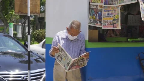 Close-up of an old man reading a newspaper in a kiosk on the street 库存影片 150665830