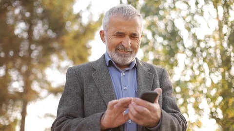 Close up of old man with white beard using smartphone outside Stock Footage 119308980