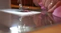Close up old married womans hands at sewing machine with pink fabric HD Footage