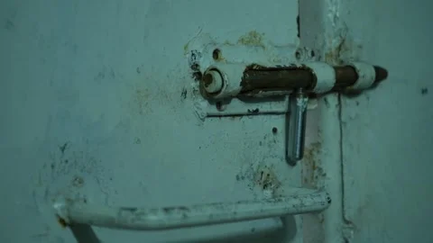 Close-up of an old metal rusty gate with a latch. A man locks an old door bolt Stock Footage 320348049