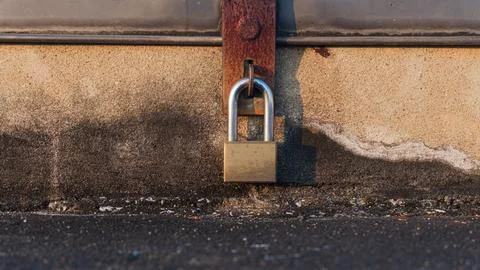 A close up of old padlock with an rusty iron latch on a cement chest Stockfoto's