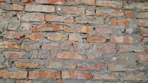 Close-up of an old red brick wall with weathered texture and uneven cement .. Vídeos de archivo 333792806