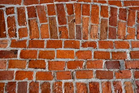 Close-up of an old red brick wall with weathered texture and white mortar Stock Photos