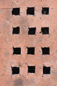 Close up of an old red ventilation brick with square holes Stock Photos