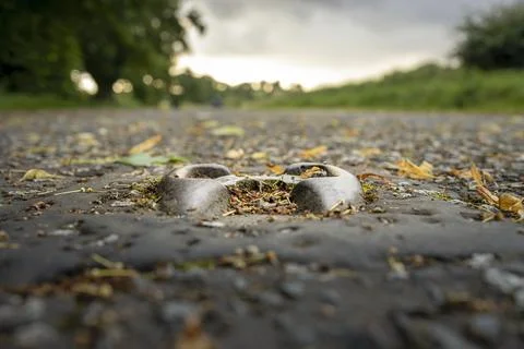 Close-up of old road stud or catseyes embedded in asphalt of a disused road Stock Photos