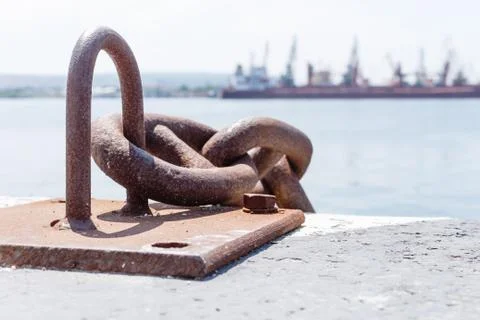Close up of old rusty chain, industrial port with ships, crane background out of Stock Photos