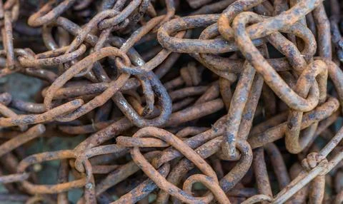 Close-up of old rusty iron chains, highlighting weathered metal texture, corr Stock Photos