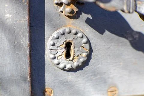 Close-up of an old, rusty keyhole on a weathered metal door. Stock Photos