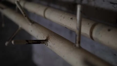 Close-up of old rusty pipes with metal pins near an old brick wall. Stock Footage 310656240