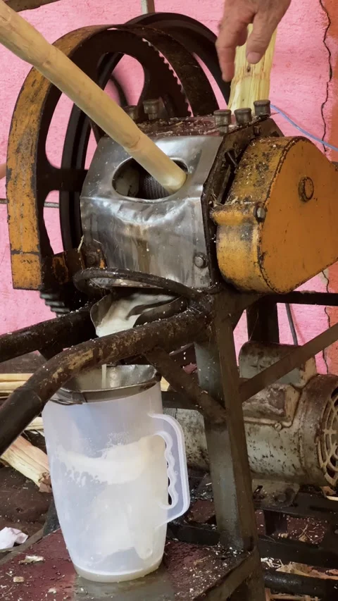Close-Up of an Old, Rusty Sugarcane Juice Machine in Action at a Busy Street Stock Footage 300602481