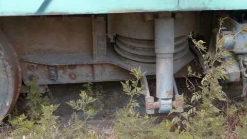 A close-up of old rusty tram chassis with wild grass growing around it Stock Footage 318686764