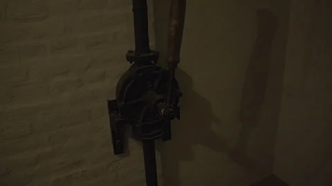 A close-up of an old, rusty water pump mounted on a brick wall. Stock-Footage 301159515