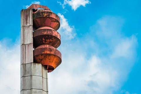 Close-up of an old, rusty water tower against a blue sky with clouds. Stock Photos