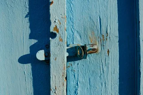 Close-up of an old slightly rusty door handle on a wooden textured door with  Stock Photos