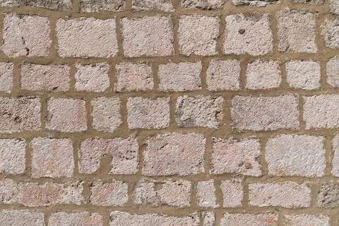 Close-up of old stone brick wall with rough texture and weathered appearance Stock Photos