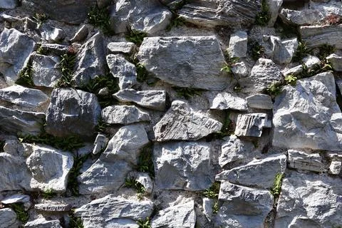 Close-up of an old stone wall with irregularly shaped rocks Stock Photos