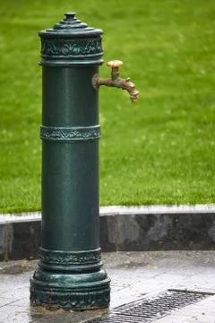 Close-up of old-style column with drinking water in public park, selective fo Stock Photos