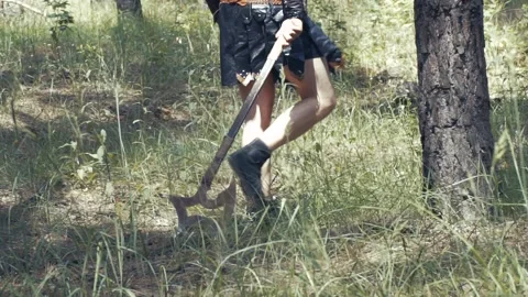 Close up of an old times warrior walking in the forest and dragging his axe Stock Footage 138423807