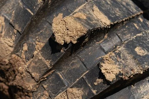 Close-up old used rubber mud terrain tire with worn wear-resistant tread Stock Photos
