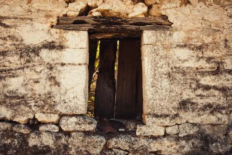 Close up of an old weathered stone wall with a rustic wooden window frame Stock Photos