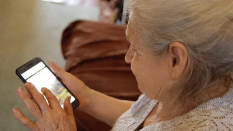 Close-up of an old woman using a smartphone to view social networks. Stock Footage 89406101