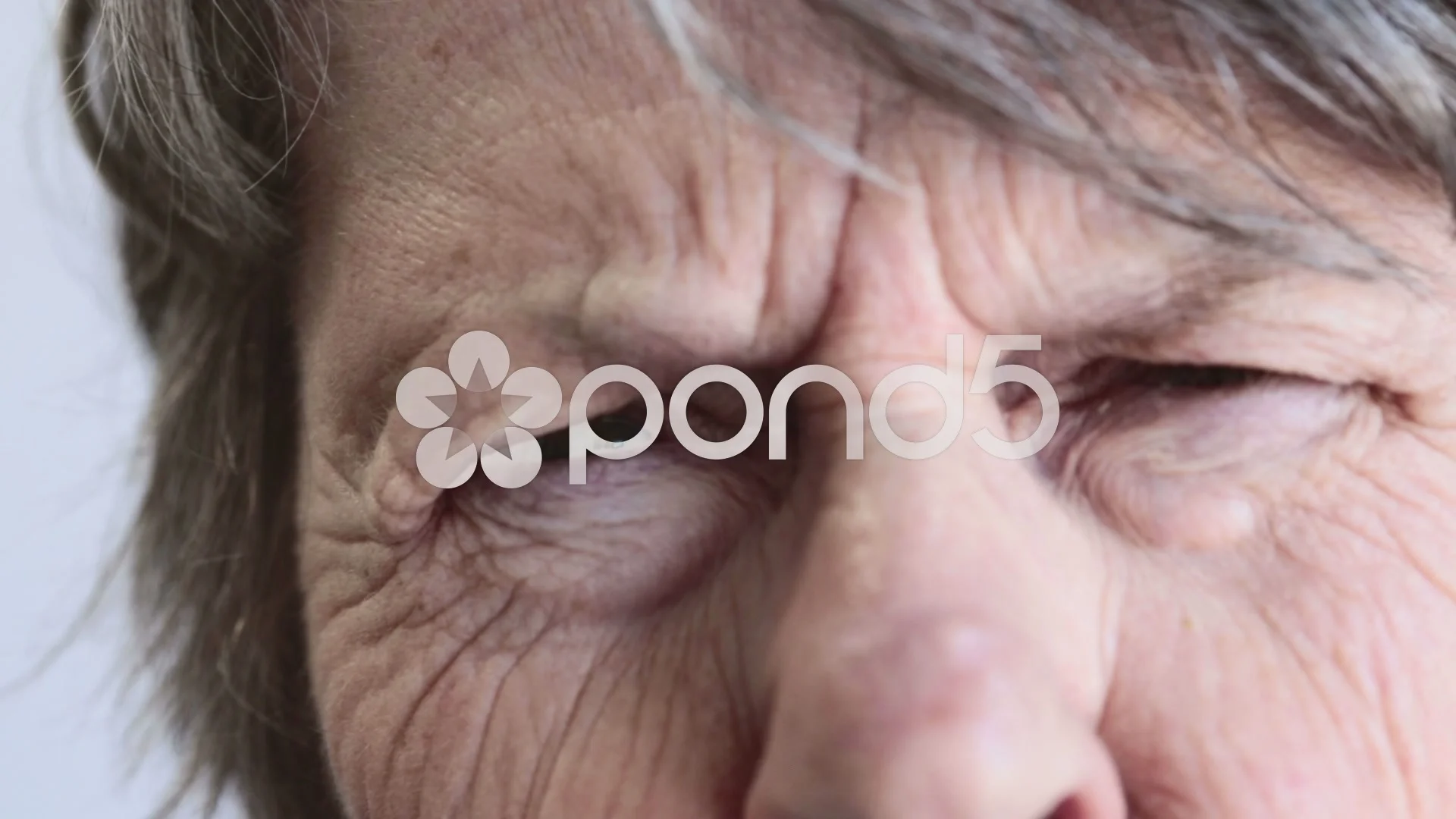 Close up of old woman with very wrinkled face squinting at camera