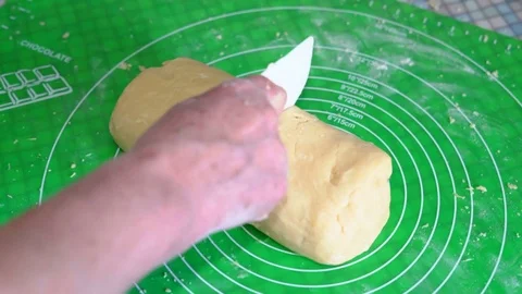 Close-up, Old Woman's Hand with Plastic Knife Cuts into Two Pieces A Piece of Stock Footage 85393700